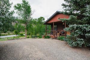 a log cabin with a gravel driveway in front of it at Fireside Cabins in Pagosa Springs