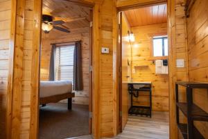 a bedroom in a log cabin with a bed and a window at Fireside Cabins in Pagosa Springs