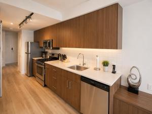 a kitchen with wooden cabinets and a sink at Perfect Brand New Studio Downtown Sidney in Sidney