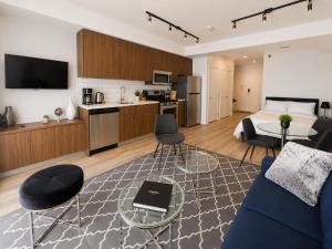a living room with a bed and a couch and a kitchen at Perfect Brand New Studio Downtown Sidney in Sidney