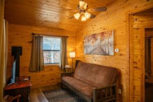 a living room with a couch and a ceiling fan at Fireside Cabins in Pagosa Springs