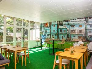 a restaurant with tables and chairs and windows at Ibis Styles Bobigny Centre Préfecture in Bobigny