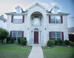 a white brick house with a red door at Pet friendly Spacious 4 Bedroom home with large, fenced backyard, located to DFW airport, restaurants and shops in Irving