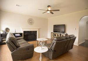 a living room with two couches and a tv at Pet friendly Spacious 4 Bedroom home with large, fenced backyard, located to DFW airport, restaurants and shops in Irving