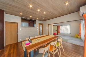 a dining room with a large wooden table and chairs at Third Place Villa KISARAZU in Kisarazu