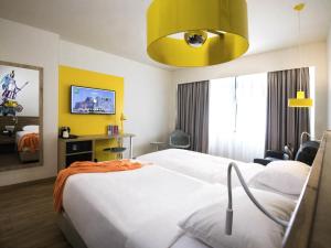 a hotel room with a bed and a yellow ceiling at ibis Styles Athens Routes in Athens