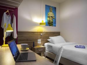 a bedroom with a bed and a laptop on a desk at ibis Styles Athens Routes in Athens