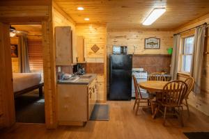 a kitchen with a table and a black refrigerator at Fireside Cabins in Pagosa Springs