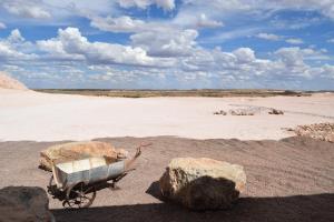 a wheelbarrow with two large rocks in a desert at Dug Out B&B Apartments in Coober Pedy