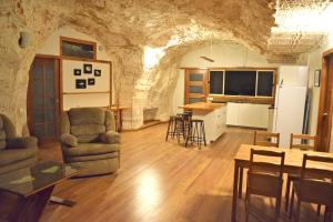 a living room with a couch and a table and a kitchen at Dug Out B&B in Coober Pedy