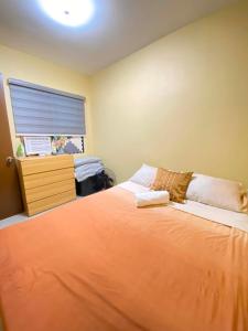 a bedroom with a large orange bed and a window at Kendras Happy Place Butuan near CSU in Butuan