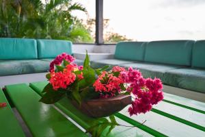 a vase of red flowers on a coffee table at Casa de Campo con Vista al Mar in Tubará