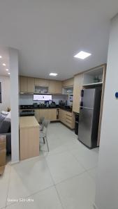 a large kitchen with a refrigerator and a table at Refúgio à Beira-Rio em Condomínio Exclusivo in Barreirinhas