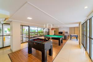 a pool room with two billiard tables and windows at Apartamento a beira-mar com piscina in Cabedelo