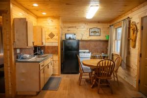 a kitchen with a table and a black refrigerator at Fireside Cabins in Pagosa Springs +18 photos