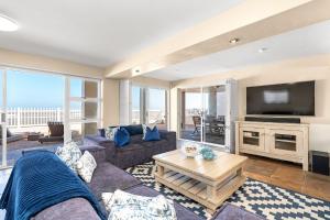 a living room with a couch and a tv at Sea Haven 4 in Gordonʼs Bay
