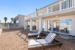 a patio with two lounge chairs and a house at Sea Haven 4 in Gordonʼs Bay