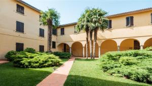 a courtyard with palm trees and a building at Casa Anna in Paratico