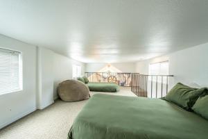 a bedroom with a green bed and a balcony at Emmanuel in Fort Bragg
