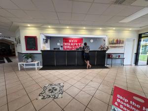 a man standing at a counter in a lobby at Red Carpet Inn Kinston in Kinston