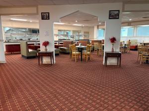a restaurant with tables and chairs in a building at Red Carpet Inn Kinston in Kinston