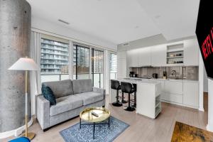 a living room with a couch and a kitchen at Altitude Residences in Toronto