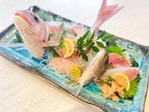 a plate of food with fish and vegetables on it at ハーミットクラブ in Goto