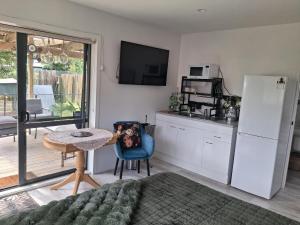 a kitchen with a table and a refrigerator at Private Studio providing a comfortable space in Paraparaumu