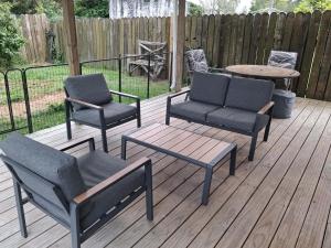 three chairs and a table and two chairs on a deck at Private Studio providing a comfortable space in Paraparaumu +4 photos