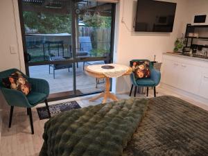 a living room with a table and two chairs at Private Studio providing a comfortable space in Paraparaumu