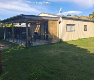 a house with a patio with a solarium at Private Studio providing a comfortable space in Paraparaumu
