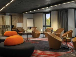 a meeting room with chairs and tables and a podium at Novotel Paris Porte Versailles in Paris