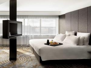 a hotel room with a bed with a tray of food on it at Pullman Rotorua in Rotorua