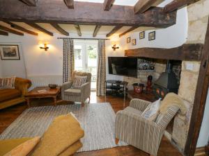 a living room with a couch and a fireplace at Elmhurst Cottage in Quinton