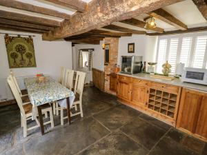 a kitchen with a table and a table and chairs at Elmhurst Cottage in Quinton