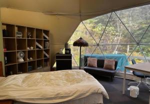 a bedroom with a large tent with a bed and a chair at 摩天轮下的森 in Tsumagoi