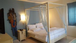 a bedroom with a canopy bed with white sheets and pillows at Sea Sight Boutique Hotel in Porto Rafti