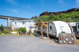 a camper parked in a parking lot next to a house at Poop Deck in Fort Bragg