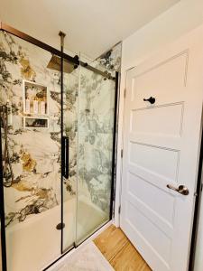 a shower with a glass door in a bathroom at Oceanside Manor - Ocean View in Qualicum Beach