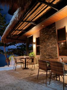 eine Terrasse mit Tisch und Stühlen und ein Gebäude in der Unterkunft Seajour Beach Resort in Ginatilan