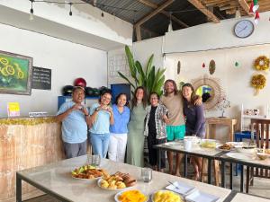 a group of people standing in a room with food at A-Manta Homestay in Labuan Bajo