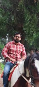a man riding a horse in front of a tree at Beverly Hills Home stay in Darjeeling