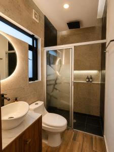 a bathroom with a toilet and a sink and a shower at Divine Comfort in Villahermosa