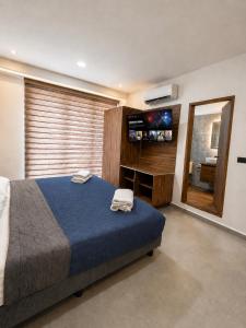 a bedroom with a large bed and a flat screen tv at Divine Comfort in Villahermosa