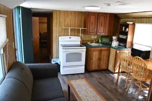 a kitchen with a couch and a stove and a table at Private Beach Access -Cottage 15 in Sauble Beach