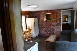 a kitchen and living room with a brick wall at Private Beach Access -Cottage 15 in Sauble Beach