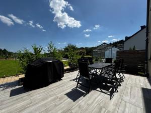 a patio with a table and chairs on a deck at Zen House - Shopping at 3 min in Marnach +41 photos
