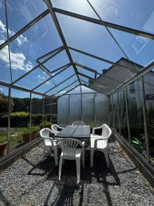 a patio with a table and chairs in a greenhouse at Zen House - Shopping at 3 min in Marnach