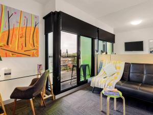 a living room with a couch and a chair at Mercure Bendigo Schaller in Bendigo