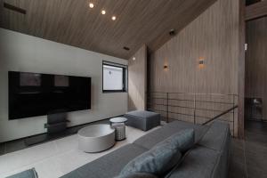 a living room with a couch and a flat screen tv at Forest Resort Walnut in Hakuba